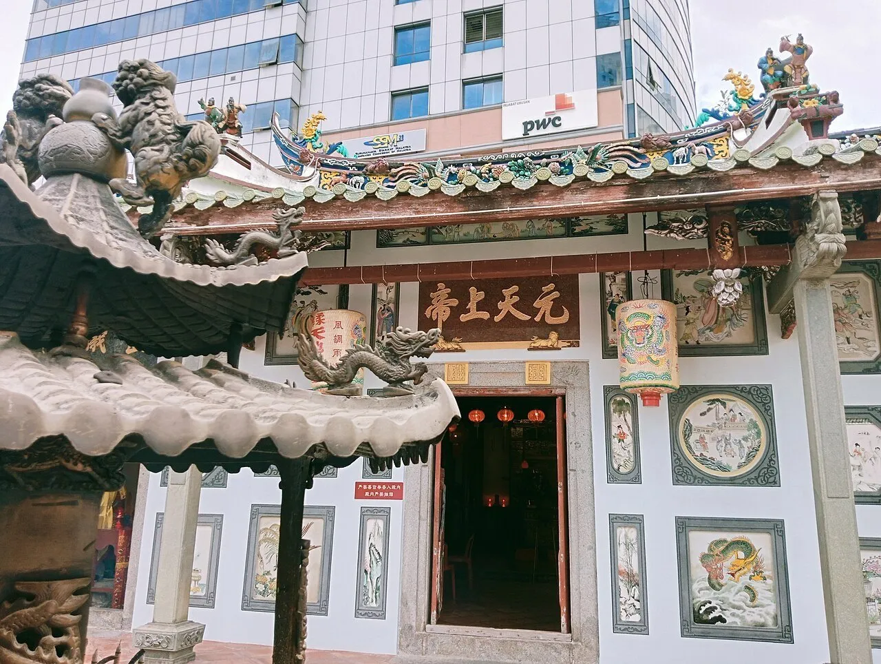 Pátio do Antigo Templo Chinês de Johor, com incensário, telhado ornamentado e fachada decorada.