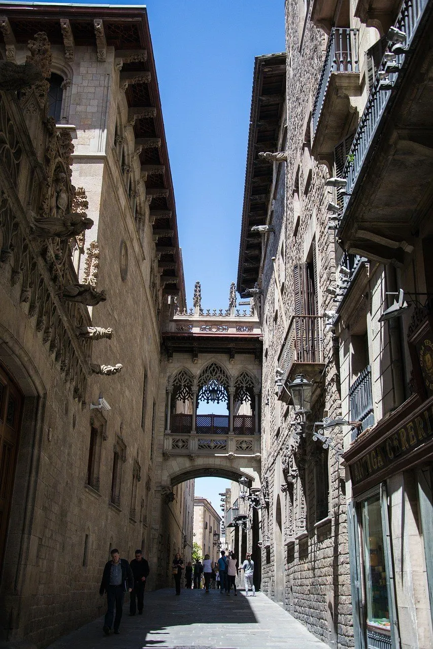 Passarela ornamentada sobre o Carrer del Bisbe, entre edifícios de pedra no Bairro Gótico.