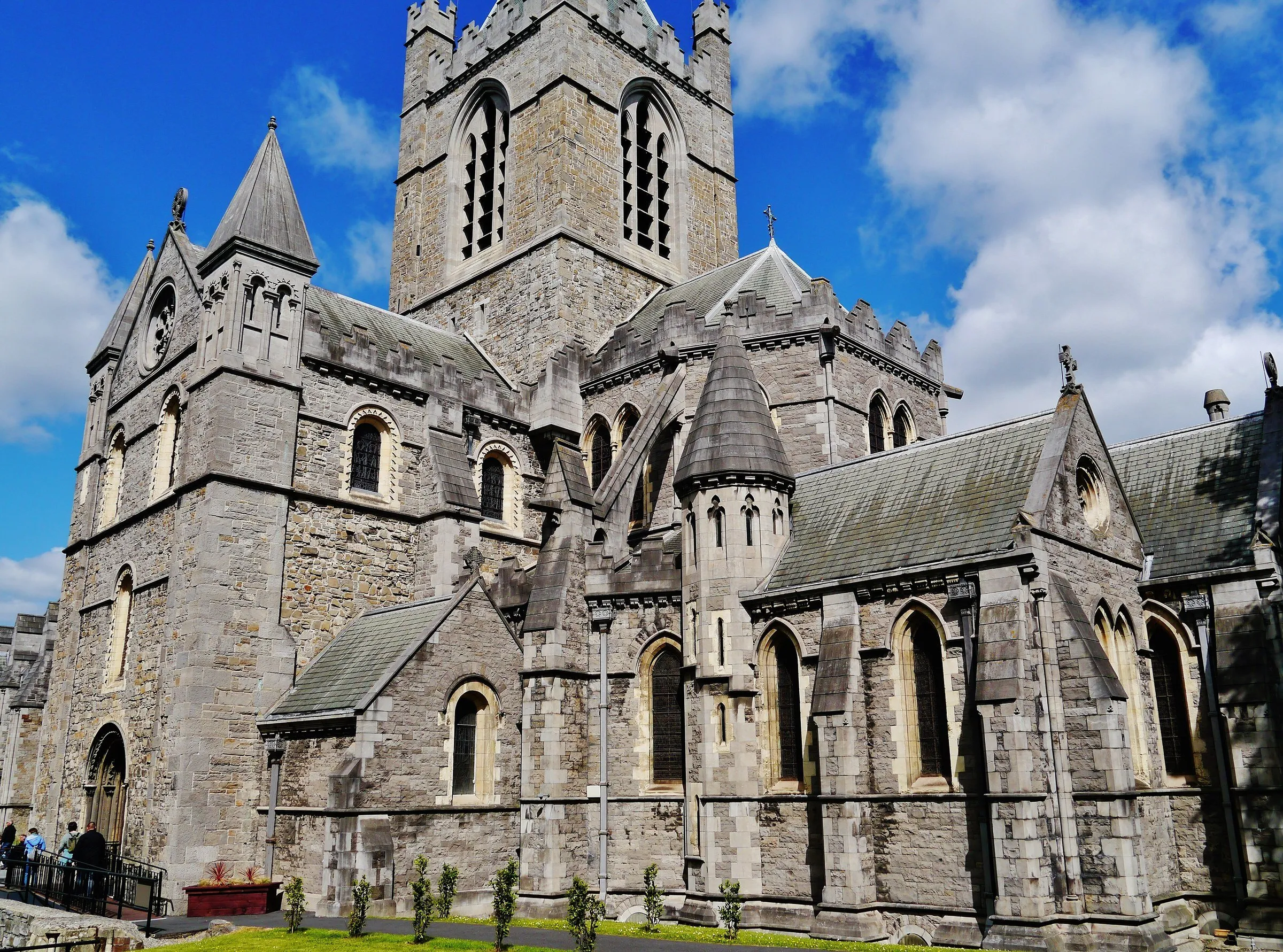 Detalhe do exterior de Christ Church Cathedral, com janelas ogivais, telhados de pedra e parte da torre.