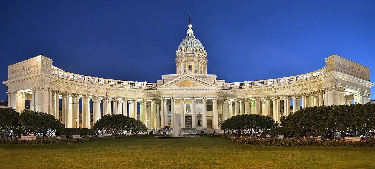 Catedral de Kazan e sua colunata curva iluminadas ao anoitecer, vistas de frente do jardim.