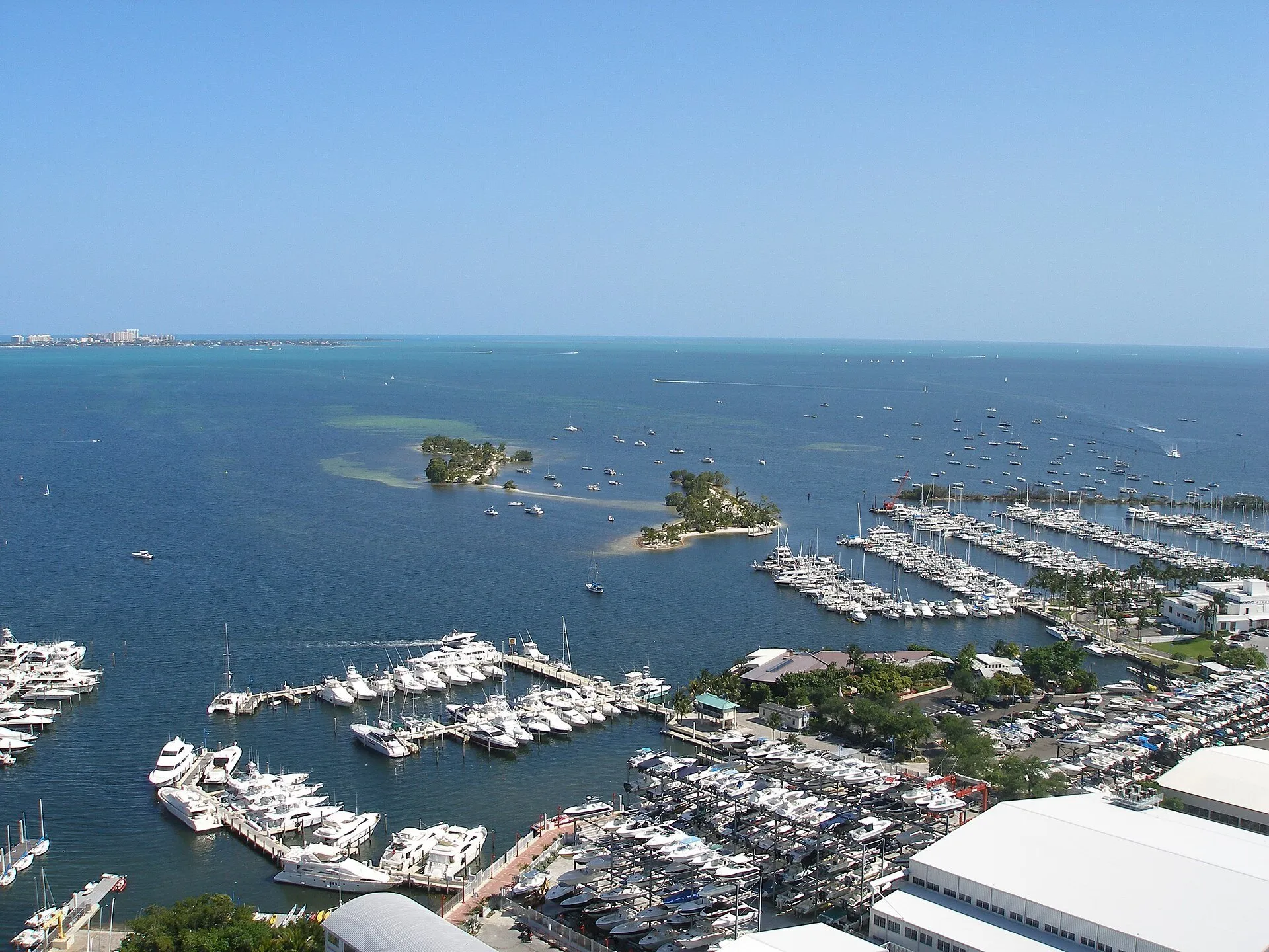 Vista elevada da marina de Coconut Grove, com barcos, pequenas ilhas e a baía de Biscayne ao fundo.