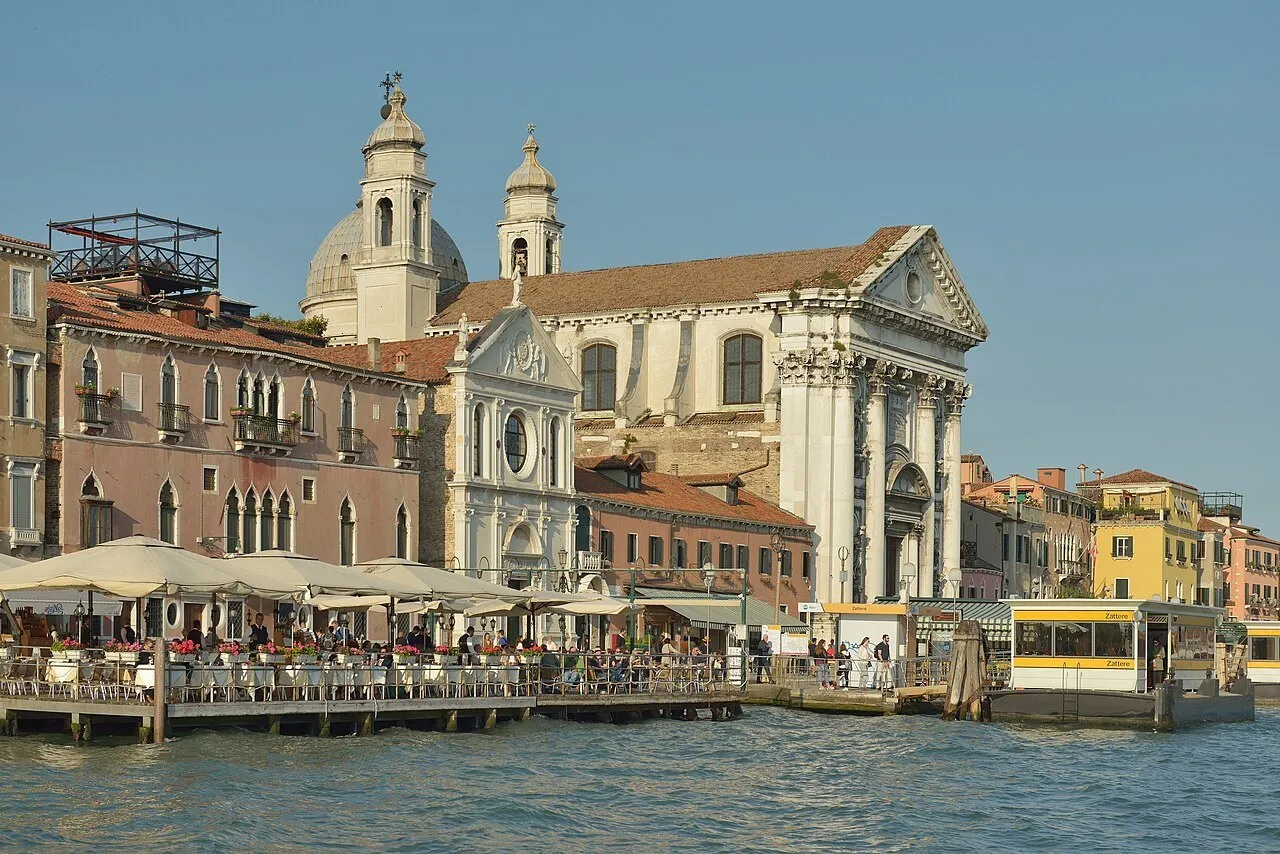 Orla das Zattere em Dorsoduro, com igrejas, mesas de café e parada de vaporetto diante do canal da Giudecca.
