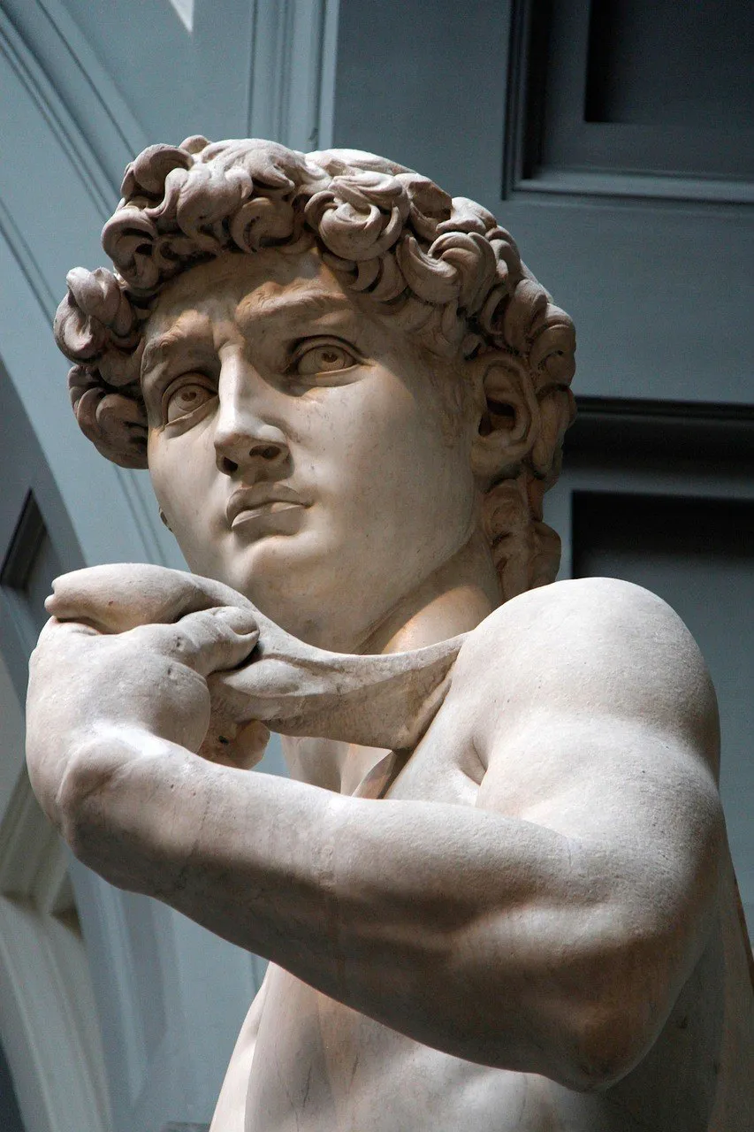 Rosto e braço do David de Michelangelo, com teto da Galleria dell’Accademia ao fundo.