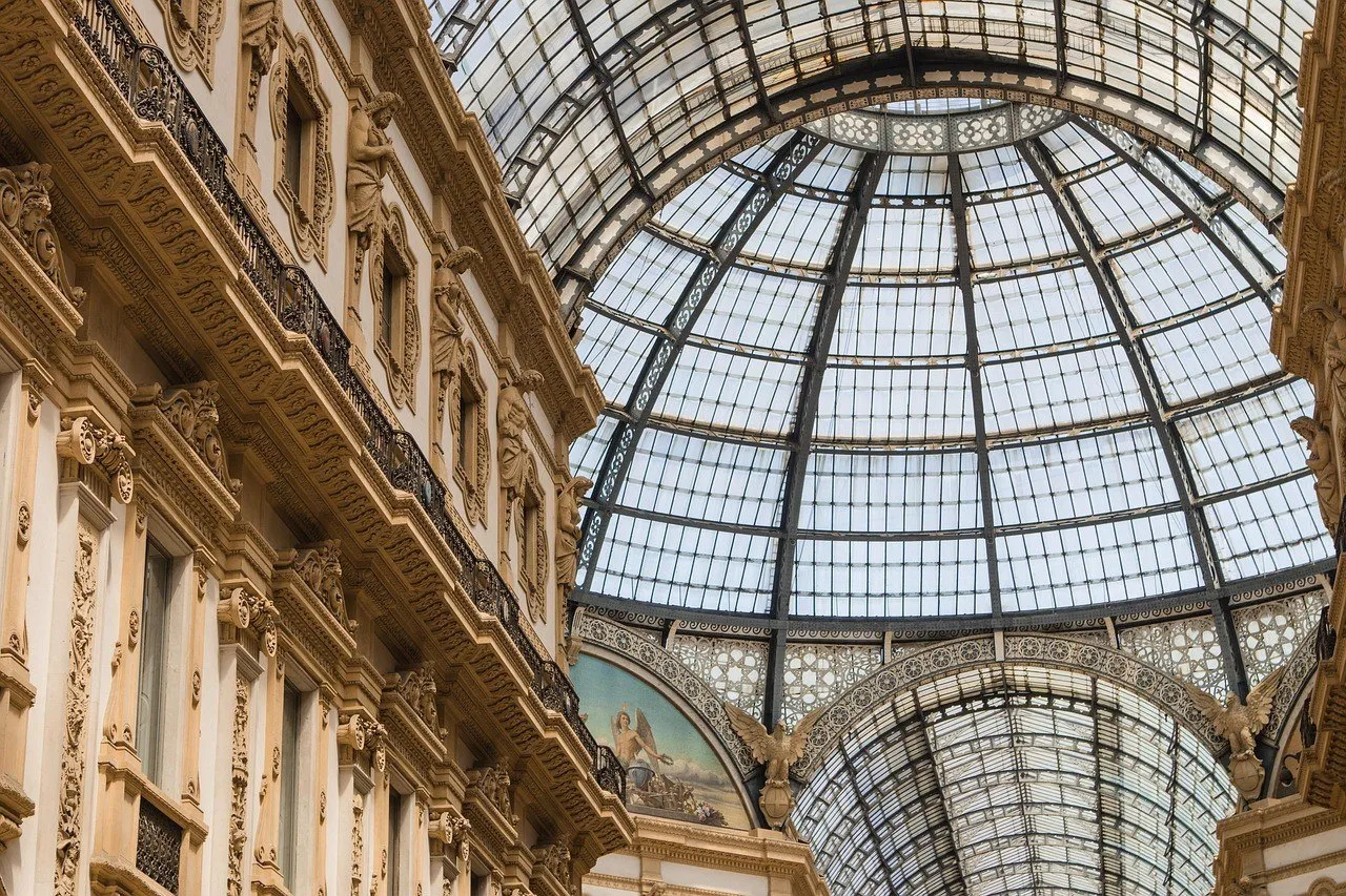 Cúpula de vidro e ferro da Galleria Vittorio Emanuele II, entre fachadas internas ornamentadas.