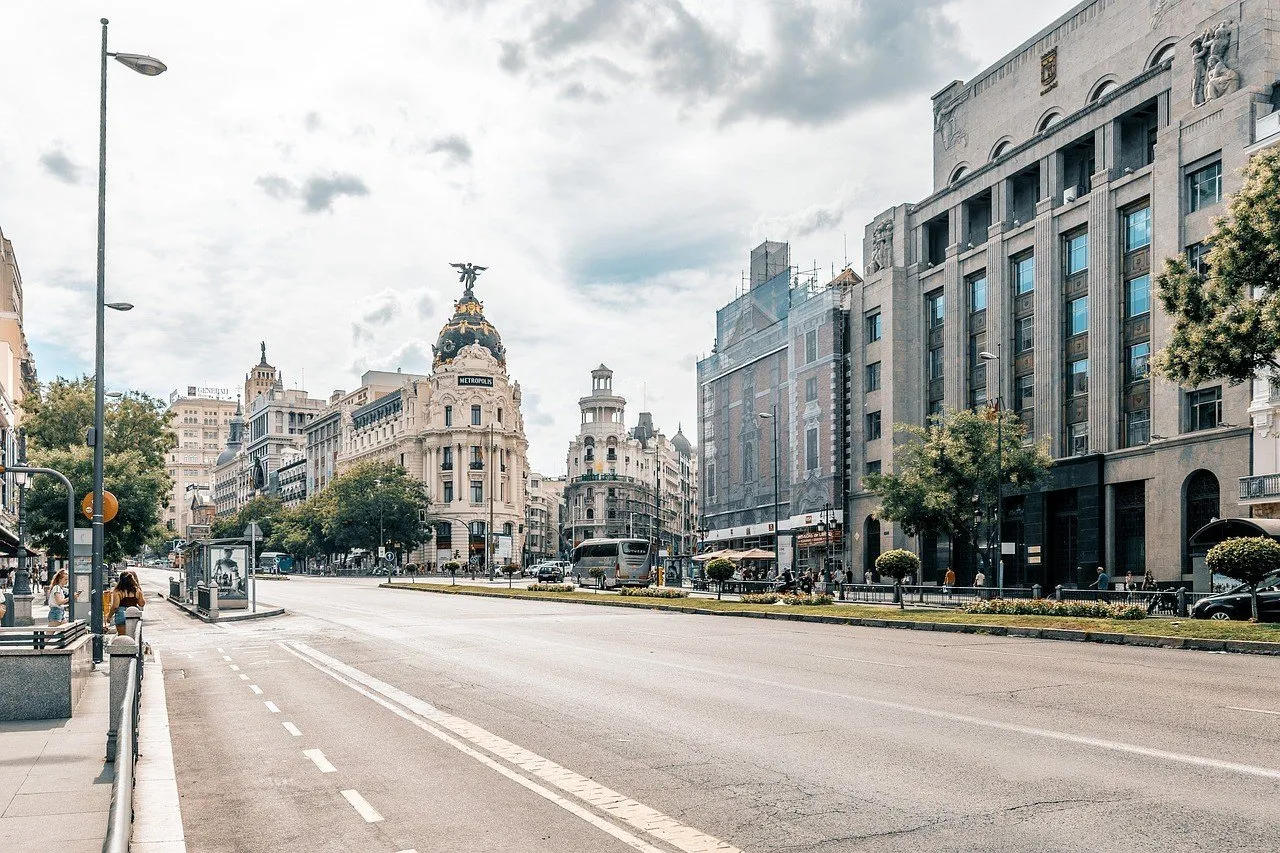 Edifício Metrópolis e começo da Gran Vía vistos da Calle de Alcalá, com fachadas e calçada.