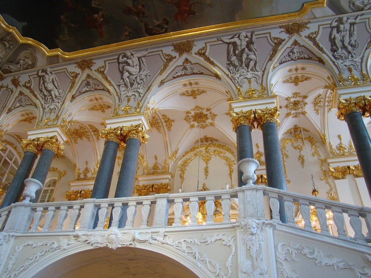 Escadaria Jordão do Hermitage, com balaustrada branca, colunas cinzentas e ornamentos dourados.