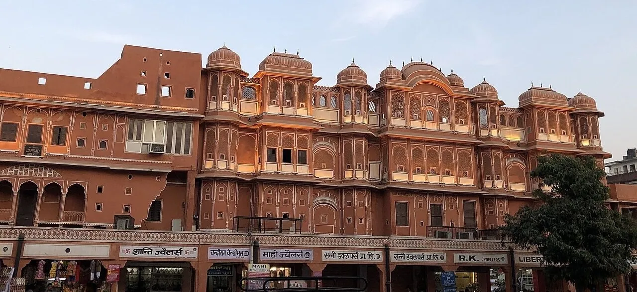 Fachadas rosadas com janelas ornamentadas e letreiros de joalherias em Johari Bazaar, Jaipur.