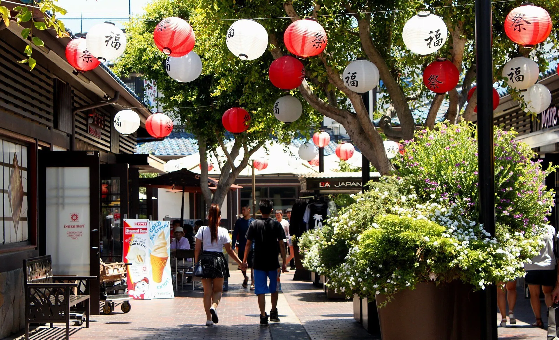 Lanternas vermelhas e brancas sobre o caminho entre lojas do Japanese Village Plaza, em Little Tokyo, Los Angeles.
