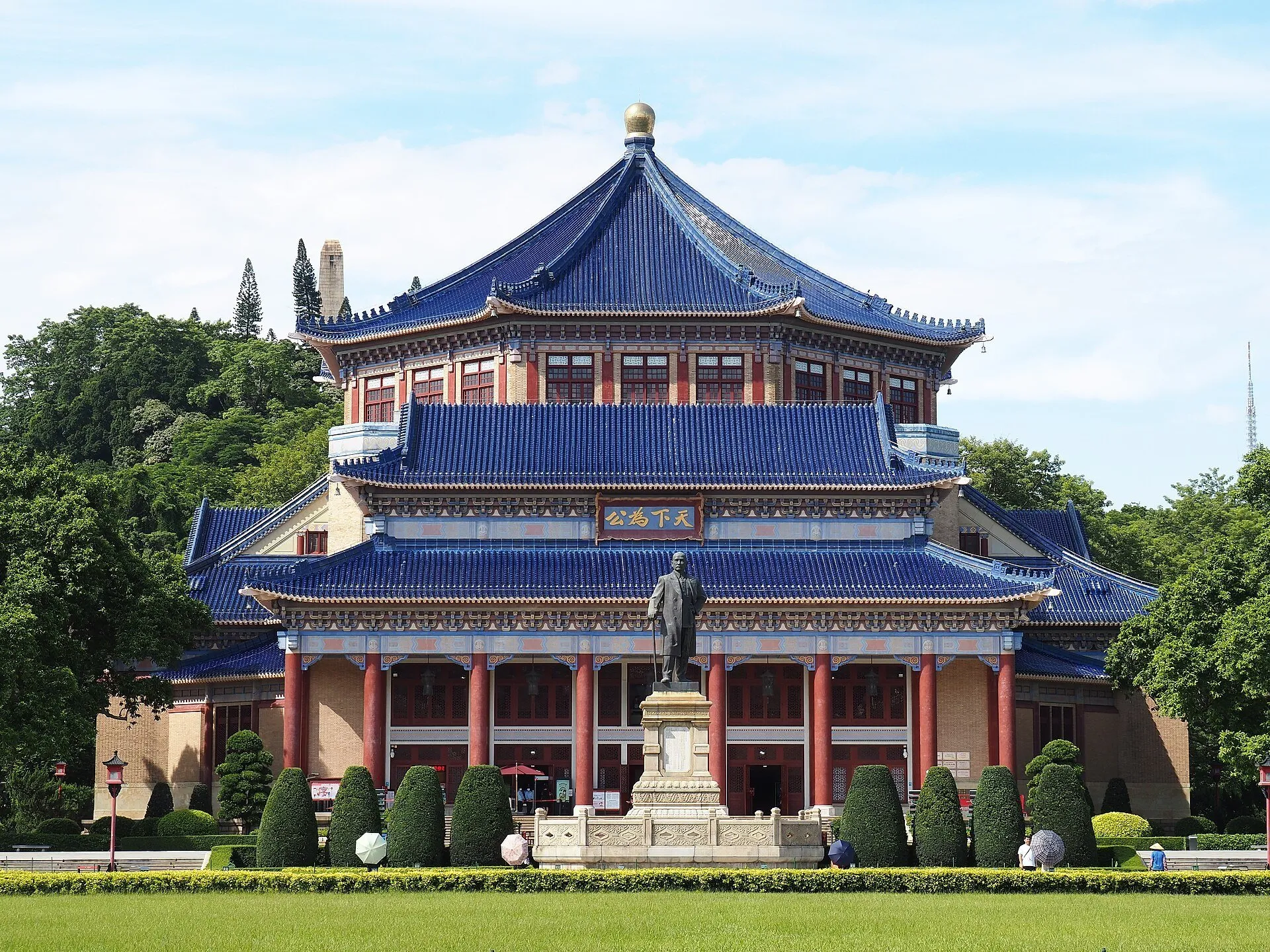 Memorial Sun Yat-sen com telhados azuis, colunas vermelhas, estátua central e gramado em frente.