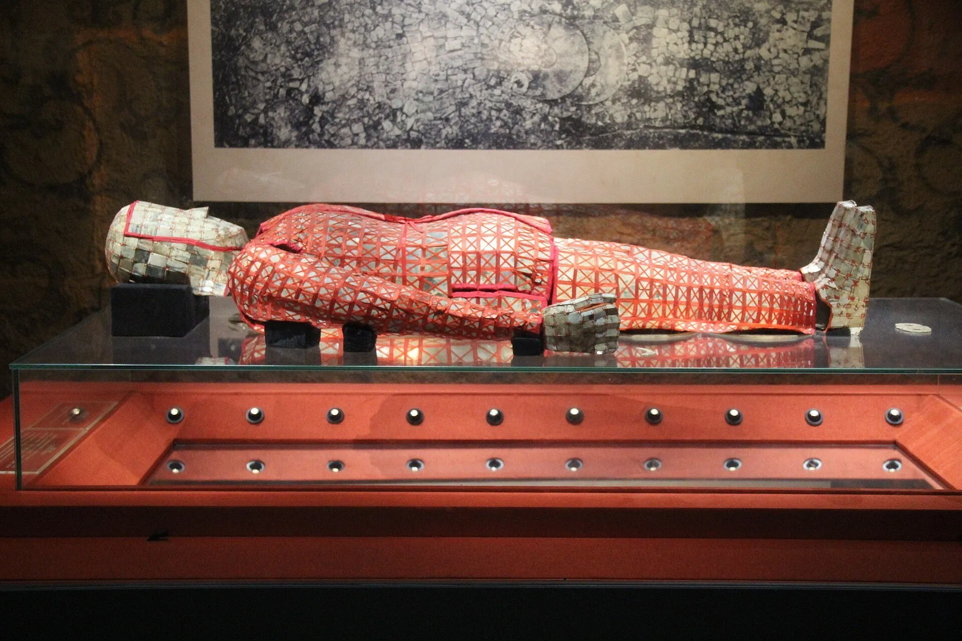 Roupa funerária de jade com fios vermelhos, exposta deitada em uma vitrine do Museu do Rei de Nanyue.
