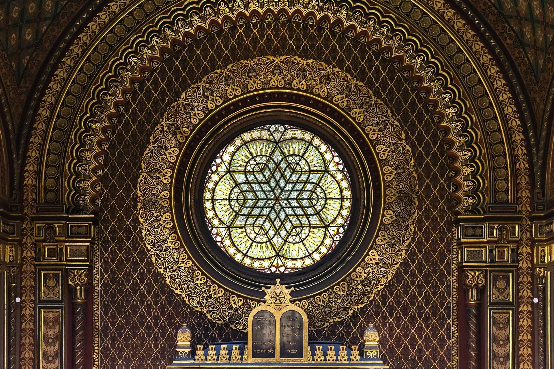 Vitral circular com estrela de Davi e ornamentação dourada no interior da Sinagoga Espanhola de Praga.