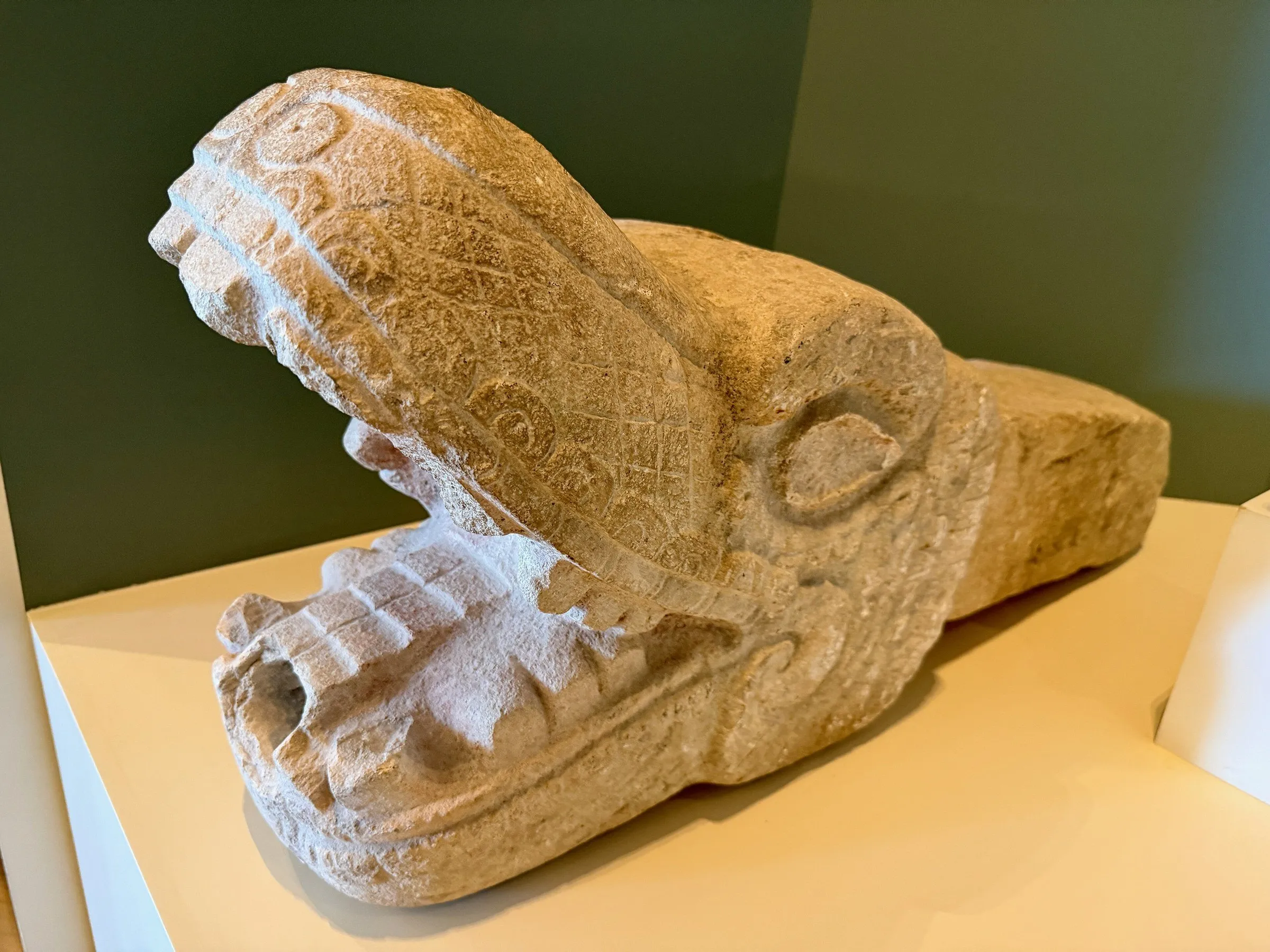 Escultura em pedra de uma cabeça com a boca aberta, exposta no Museu Maia de Cancún.