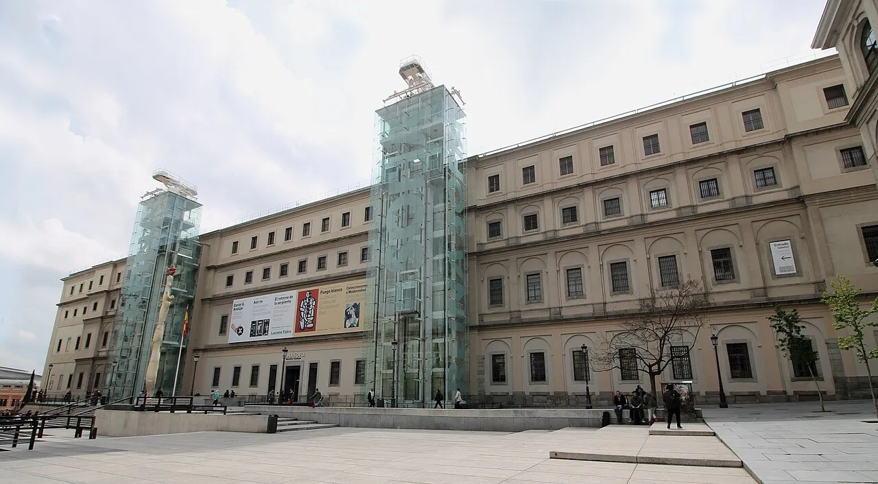 Fachada do edifício Sabatini do Museu Reina Sofía, com duas torres de vidro e poucos visitantes.