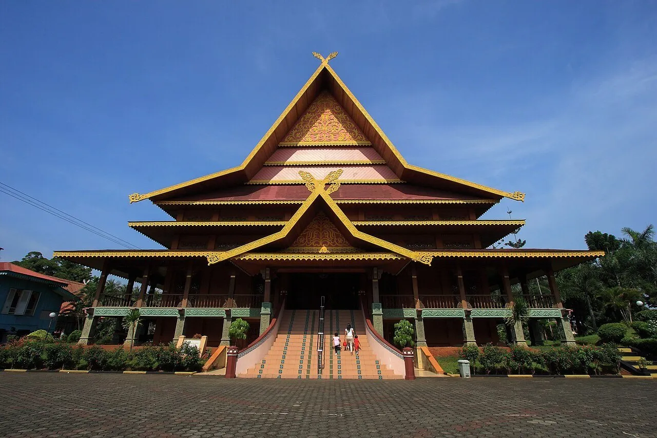 Pavilhão tradicional com telhados sobrepostos e ornamentos dourados no Taman Mini Indonesia Indah.