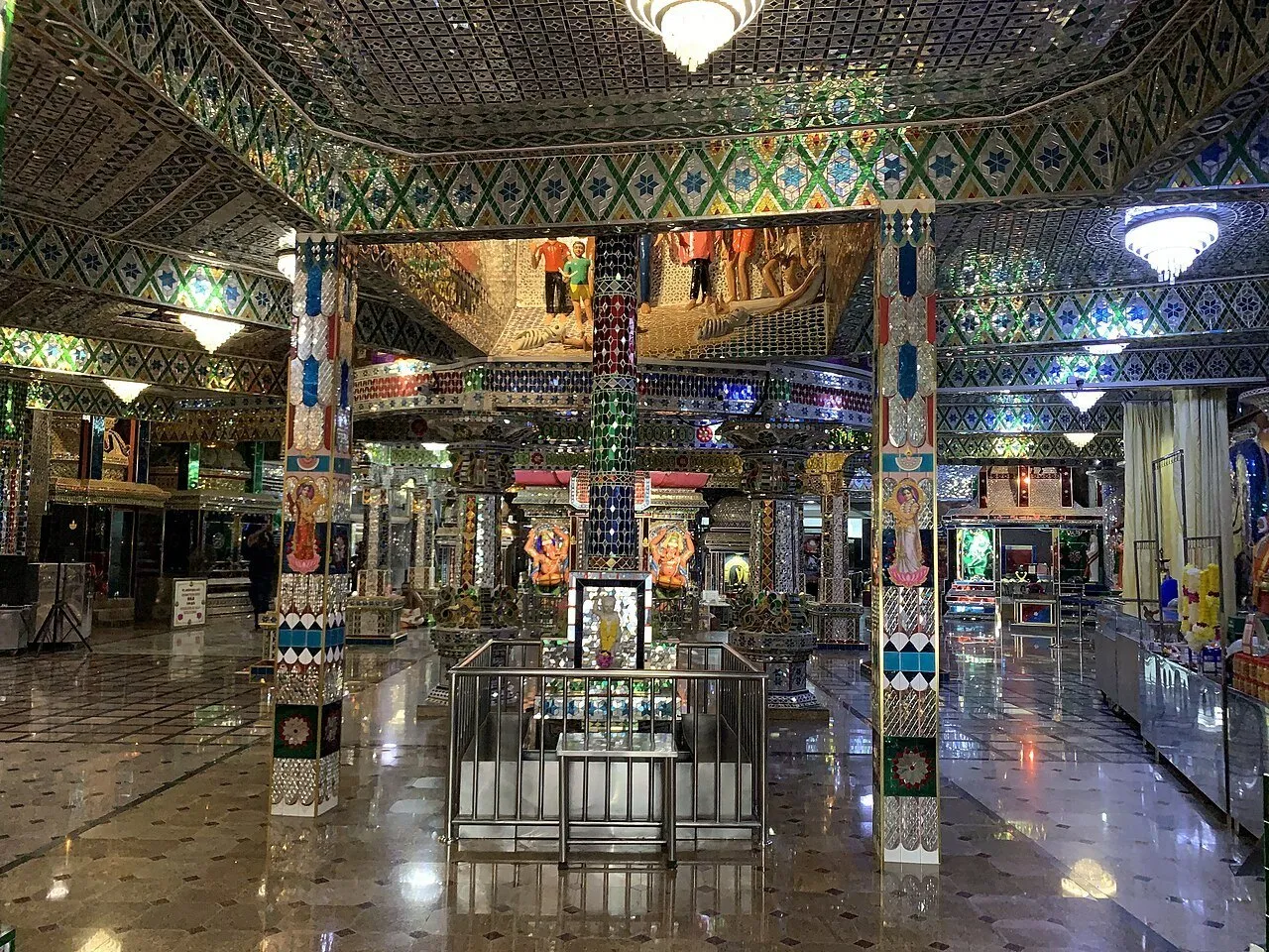 Interior do Templo de Vidro Sri Rajakaliamman em Johor Bahru, com colunas e teto revestidos de espelhos.