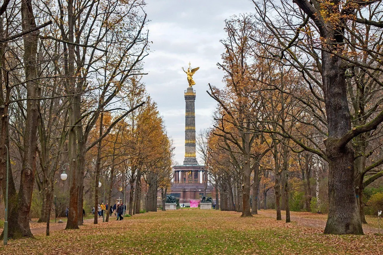 Alameda do Tiergarten com folhas de outono e Coluna da Vitória ao fundo.